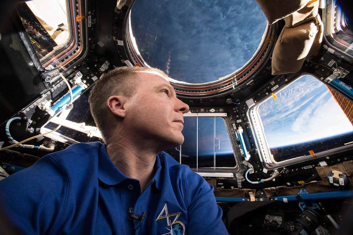 Un astronauta observando la Tierra desde la Cúpula durante la Expedición 43.